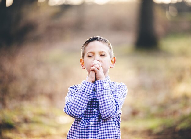 Portret van een kleine christelijke jongen die bidt