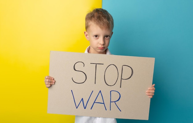 Portret van een kleine jongen die een spandoek vasthoudt met het opschrift Stop the war No war stop war