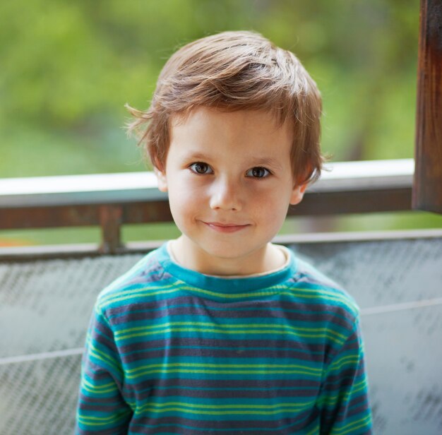 Portret van een kleine jongen die en naar u glimlacht.