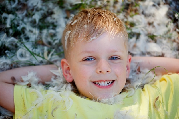 Portret van een kleine jongen die op het gras ligt