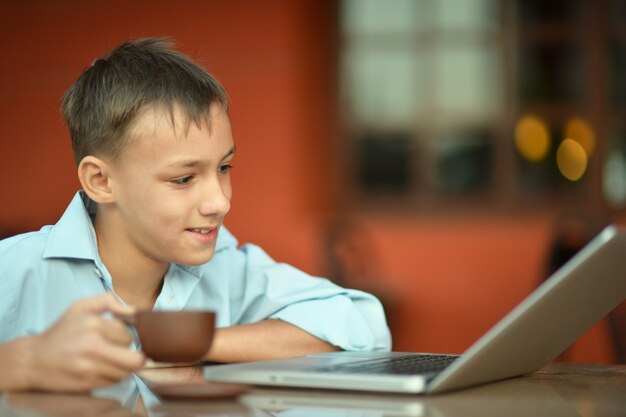 Portret van een kleine jongen met laptop op tafel