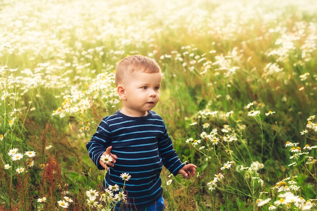 portret van een kleine jongen onder bloemen