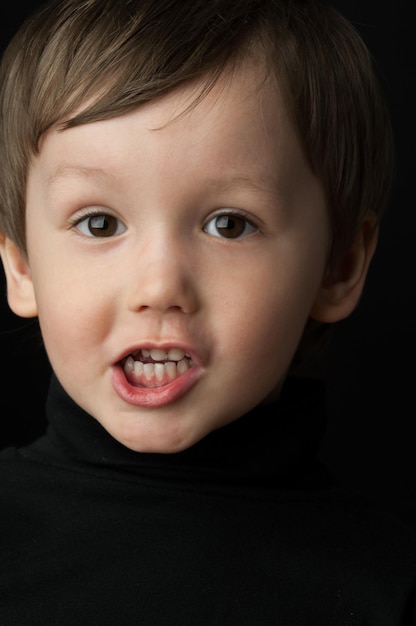 Portret van een kleine jongen op een donkere achtergrond