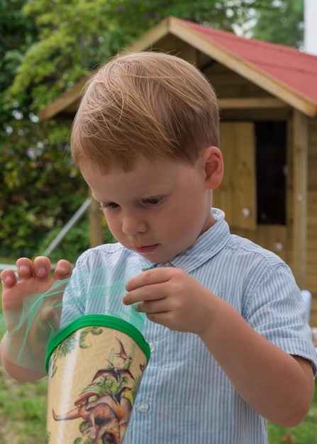 Portret van een kleine jongen Opent een snoepkegel met interesse Joy nieuwsgierigheid school