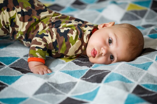 Portret van een kleine jongen van 8 maanden en lacht. Gezondheid en ontwikkeling van kinderen