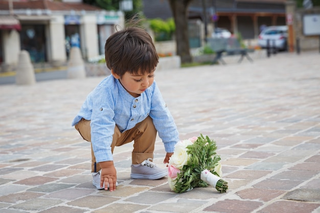 Portret van een kleine Oosterse knappe babyjongen die buiten speelt met een boeket bloemen.