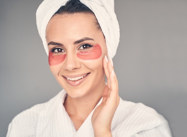 Portret van een knappe blanke meid met de hydrogel ooglapjes poserend voor de voorkant