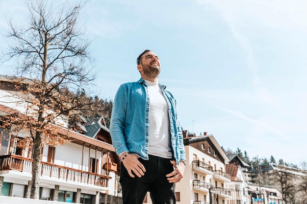 Portret van een knappe hipster-man in een jeansjasje in een grote stad op straat een levensstijlconcept