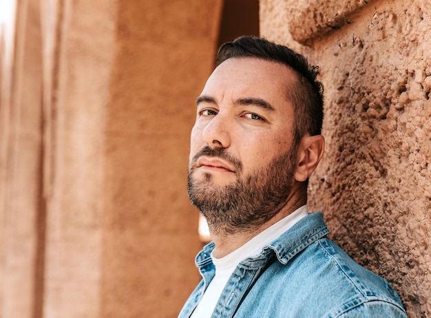 Portret van een knappe hipster man in een spijkerjas een man in een grote stad op straat een levensstijl