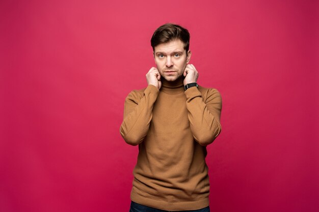 Portret van een knappe jonge man die lacht tegen roze achtergrond.