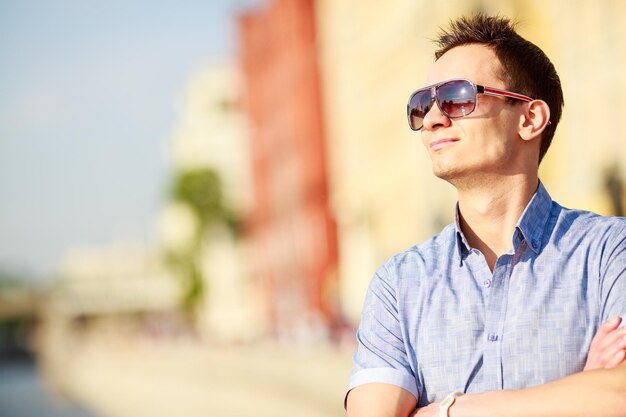 Portret van een knappe jonge man met zonnebril