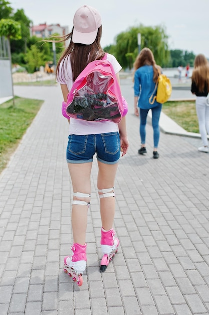 Portret van een knappe jonge vrouw in casual kleding skaten op de stoep in het park