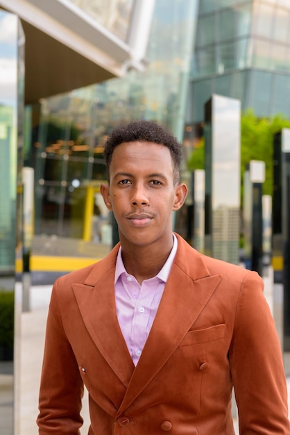 Portret van een knappe jonge zwarte Afrikaanse zakenman die stijlvolle kleding buitenshuis draagt