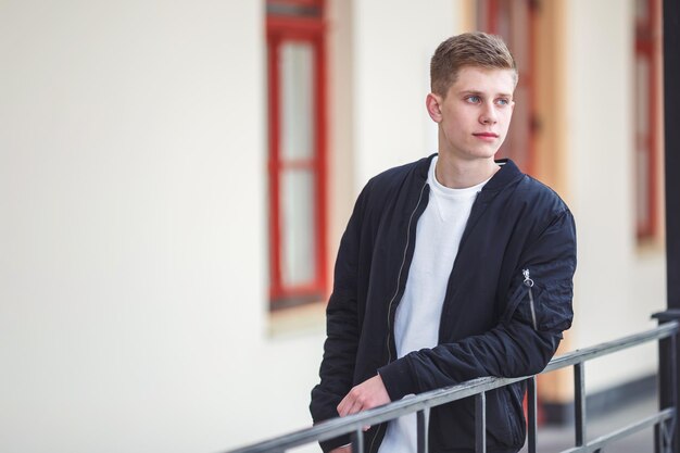 Portret van een knappe jongenstiener die door de winkels langs de straat loopt