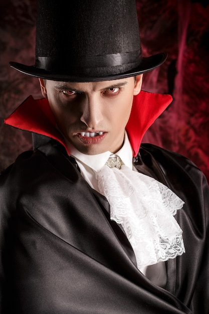 Portret van een knappe man gekleed in een Dracula-kostuum voor Halloween