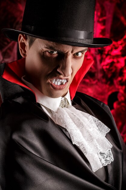 Portret van een knappe man gekleed in een Dracula-kostuum voor Halloween