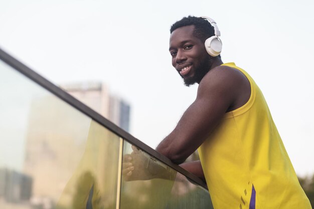 Portret van een knappe man met een zwarte huid, luistert naar muziek na de training