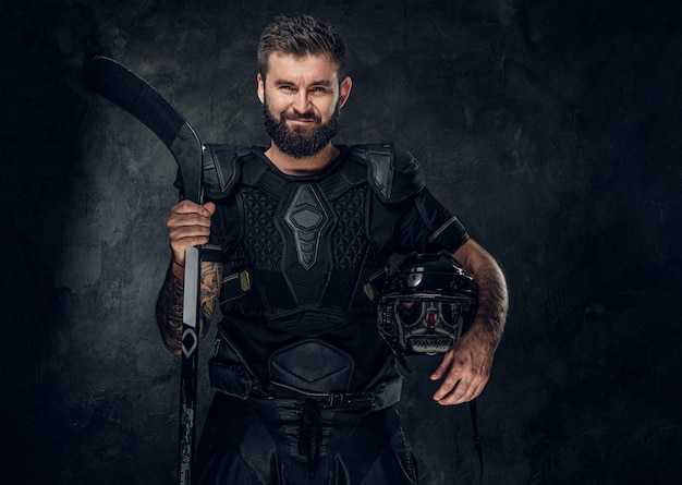 Portret van een knappe man van middelbare leeftijd met hockeystick en uniform.