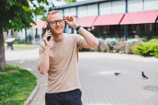 Portret van een knappe volwassen zakenman die een boodschappentas vasthoudt met een stijlvolle bril die naar de camera kijkt