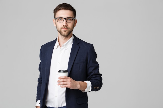 Portret van een knappe zakenman in bril met een kopje koffie.