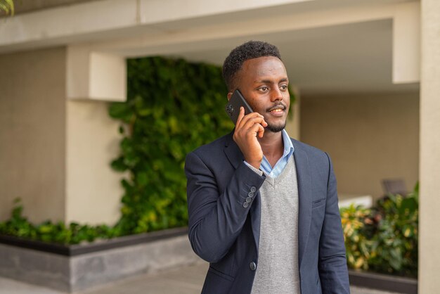 Portret van een knappe zwarte Afrikaanse zakenman die aan de telefoon praat