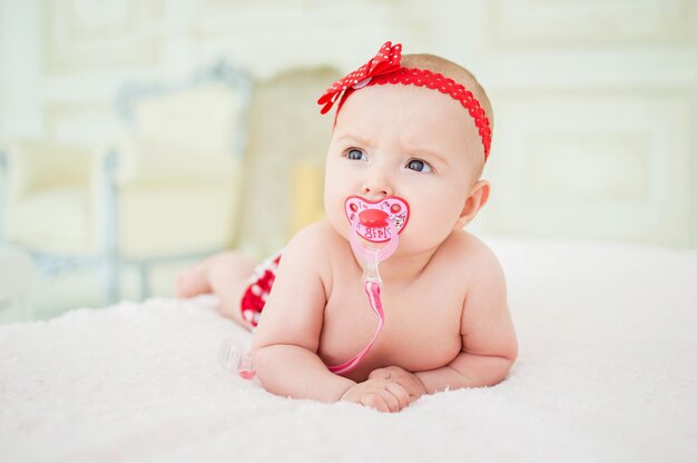 Portret van een kruipende baby op een bed in zijn kamer Het concept van een gelukkig kind