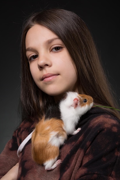 Foto portret van een lachend meisje met een cavia, dier eet gras, close-up schieten