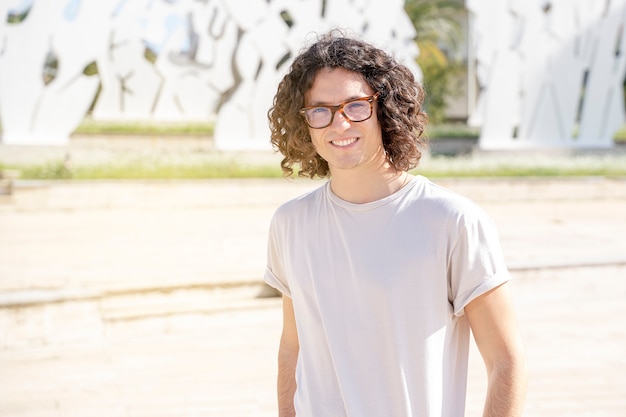 Foto portret van een lachende casual man in stedelijke achtergrond