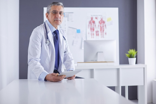 Portret van een lachende dokter in zijn heldere kantoor