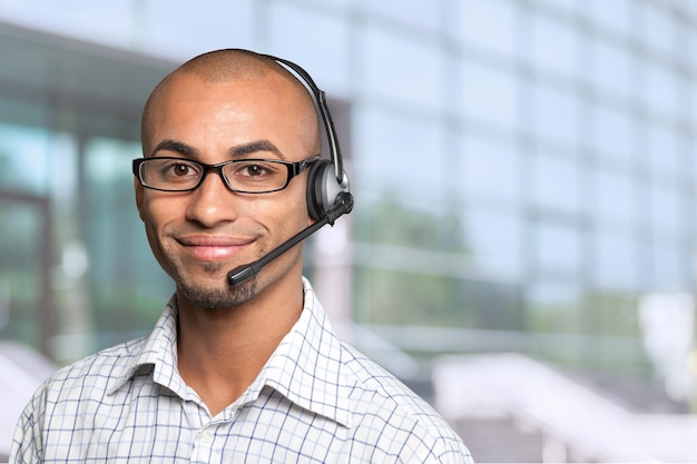 Portret van een lachende man met een headset die werkt als een callcenter-operator