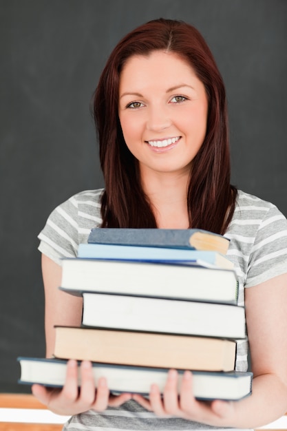 Portret van een lachende roodharige houden van boeken