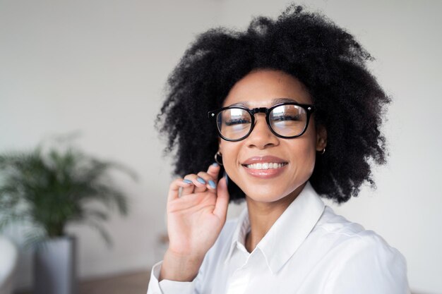 Portret van een lachende vrouw manager in een wit overhemd die op kantoor werkt en naar de camera kijkt