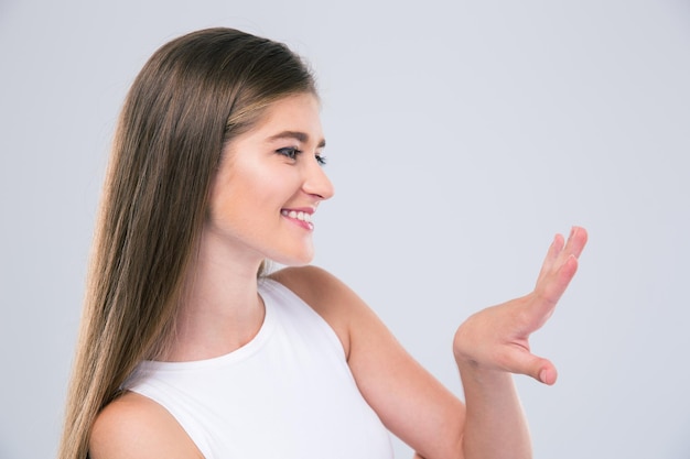 Portret van een lachende vrouwelijke tiener die naar haar nagels kijkt geïsoleerd