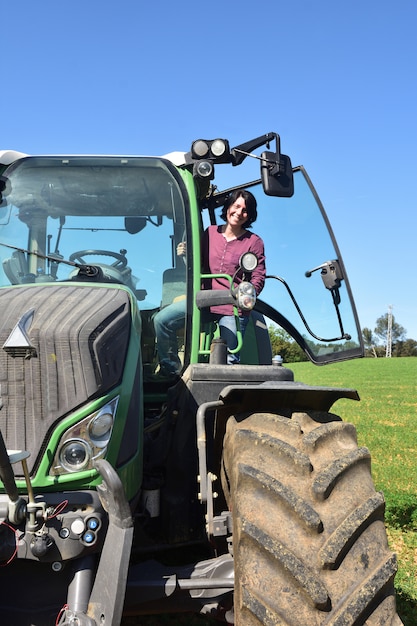 Foto portret van een landbouwersvrouw en een tractor