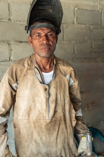 Portret van een Latijnse lasser met een masker in de werkplaats