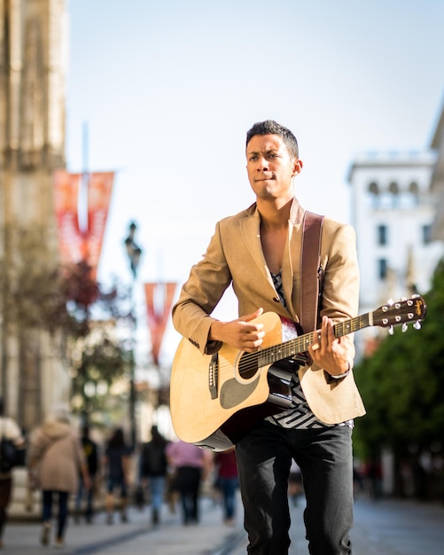 Portret van een Latijnse straatmuzikant die gitaar speelt op een drukke straat