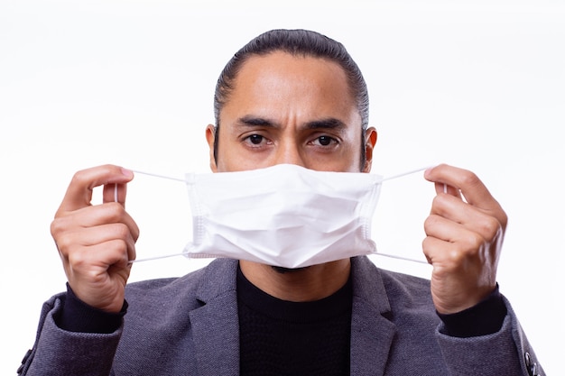 Portret van een Latino man die een medisch masker over zijn gezicht draagt