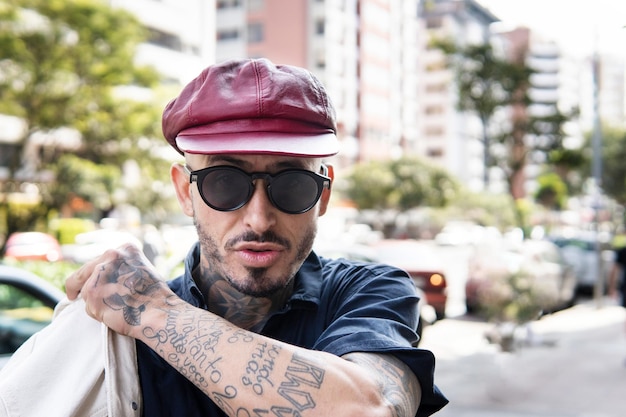 Portret van een Latino man die naar de camera kijkt en een trui aantrekt in een stedelijke omgeving