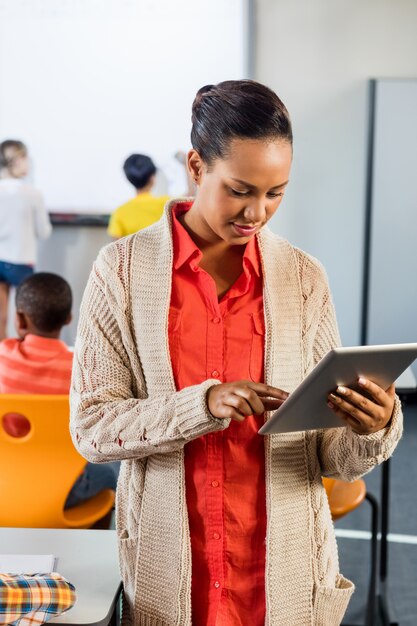 Portret van een leraar die tabletpc in klasse met behulp van