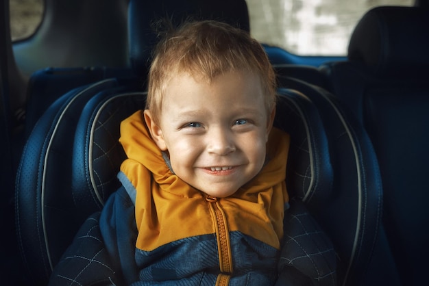 Portret van een leuke jongen die in de auto zit
