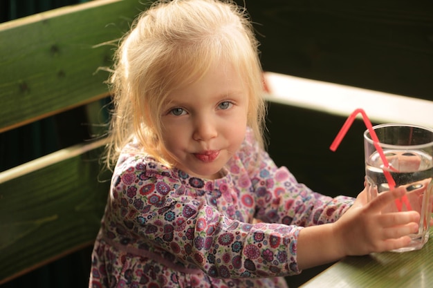 Portret van een lief, mooi meisje dat een glas water drinkt