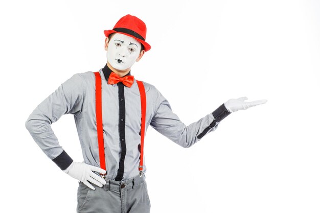 Portret van een man artistclown MIME toont iets geïsoleerd op een witte achtergrond