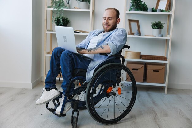 Foto portret van een man die een mobiele telefoon gebruikt terwijl hij in een rolstoel zit