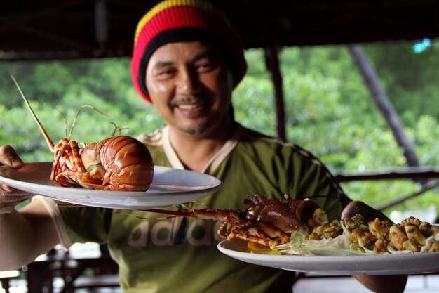 Foto portret van een man die eten vasthoudt in een restaurant