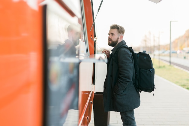 Portret van een man die fastfood kiest in een foodtruck in de voedselindustrie voor straatmaaltijden en streetfood