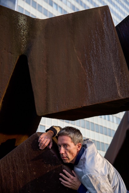 Foto portret van een man die leunt op metaal in de stad