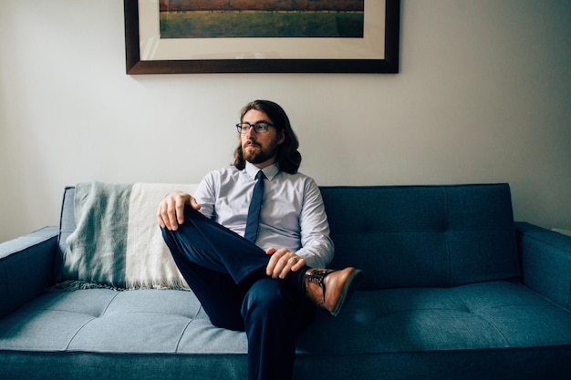 Portret van een man die op de bank zit