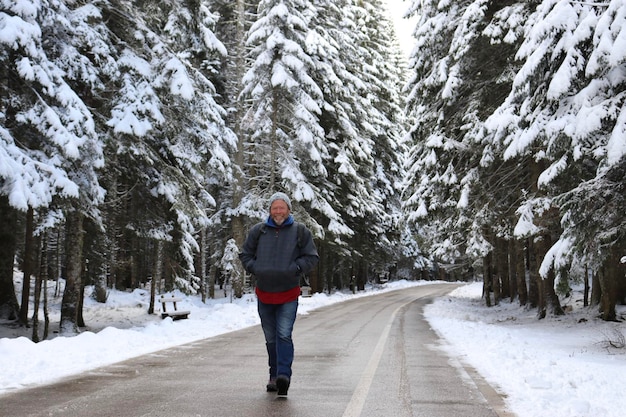 Portret van een man die op een met sneeuw bedekte weg loopt