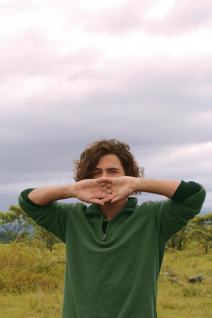 Portret van een man die op het land tegen de lucht staat