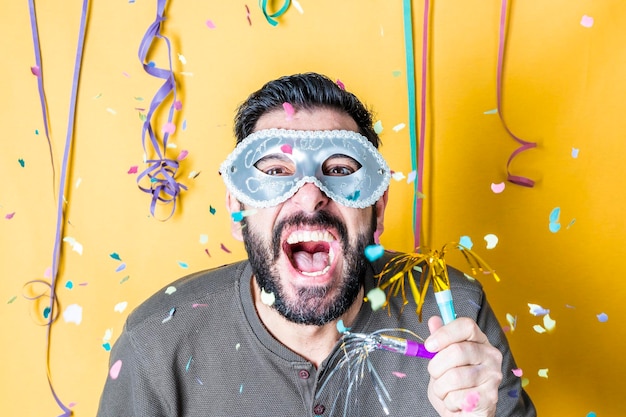 Foto portret van een man die schreeuwt terwijl hij een masker draagt tijdens een feestje